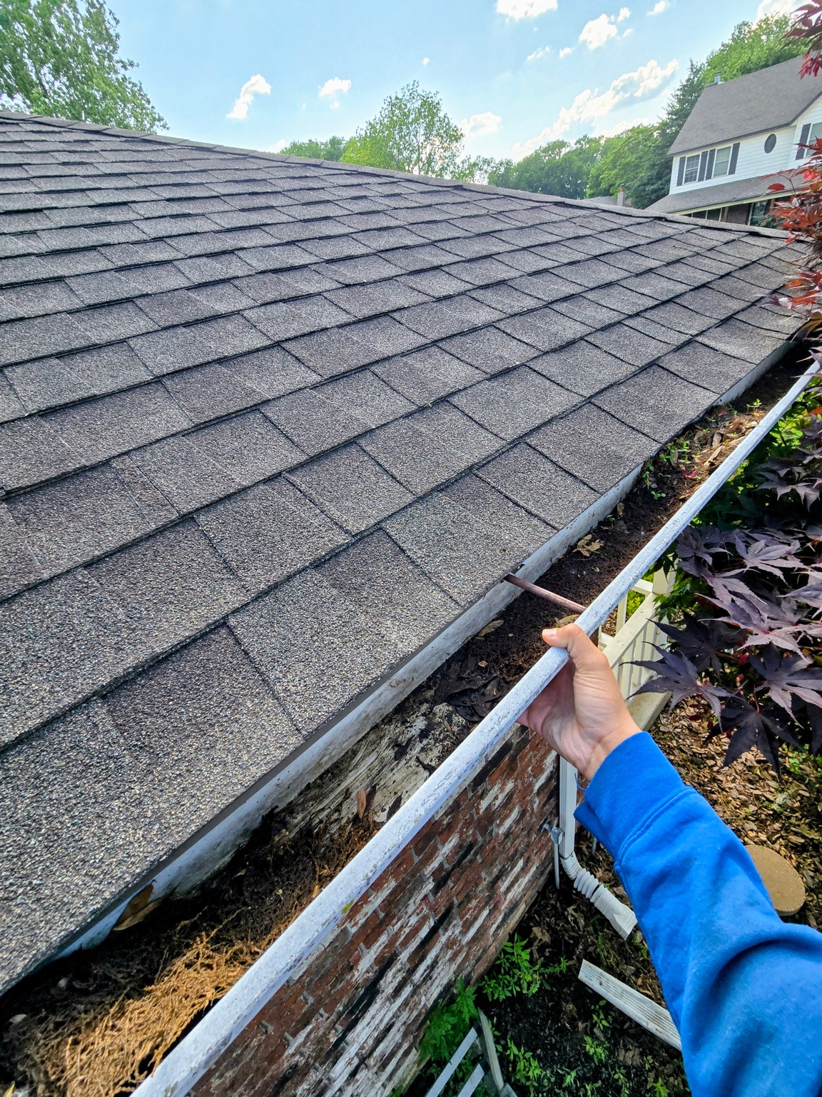 Clogged gutter mid-cleaning process Tulsa Oklahoma - debris removal by Vital Cleaning Services